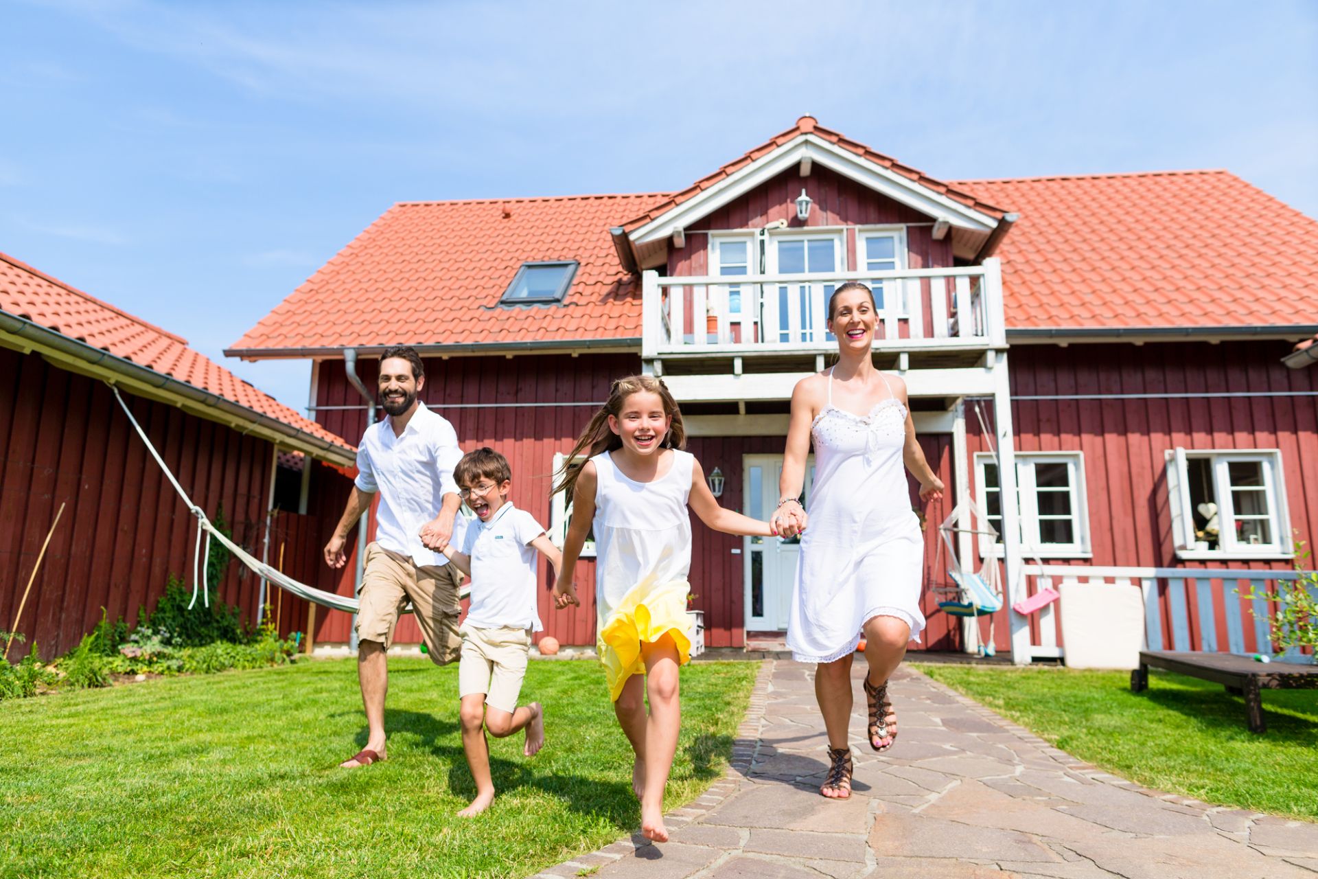 Glückliche Familie läuft Hand in Hand vor Ihrem Haus | Tipps zum Immobilienkauf am Niederrhein von Kock Immobilien